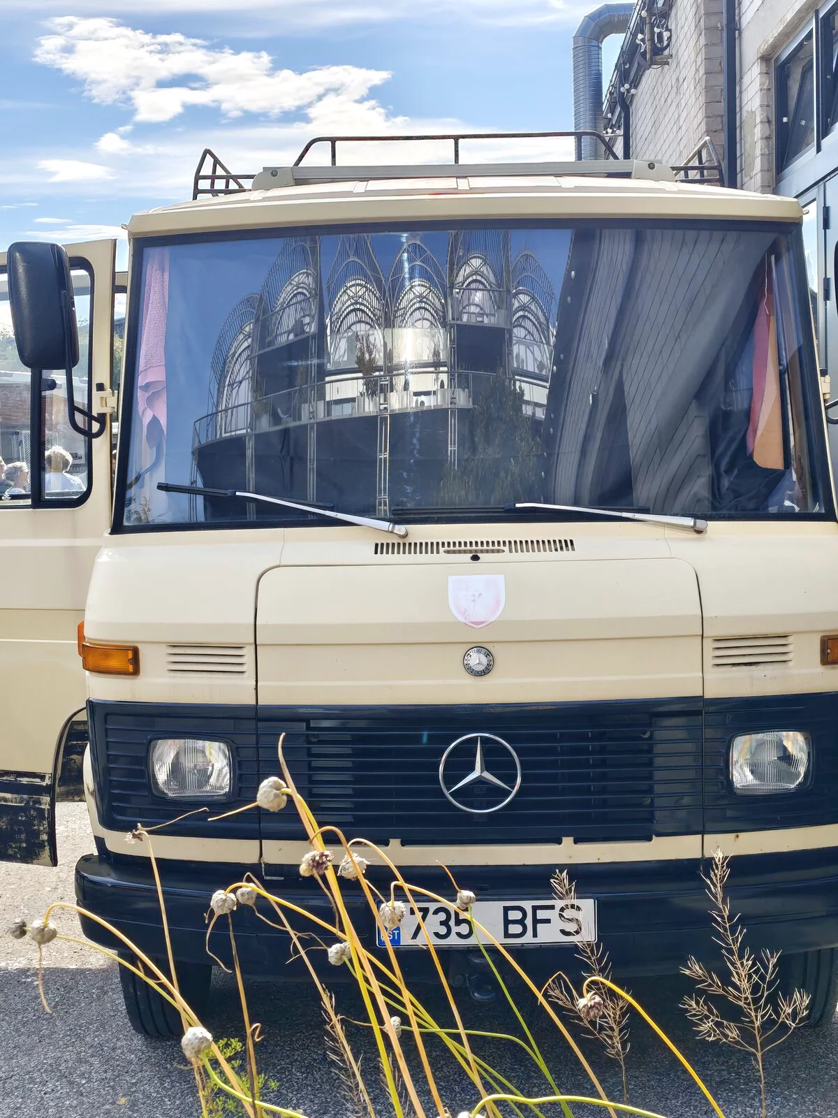 Front of the Mercedes T2, with the quarter's new buildings reflected in the windscreen