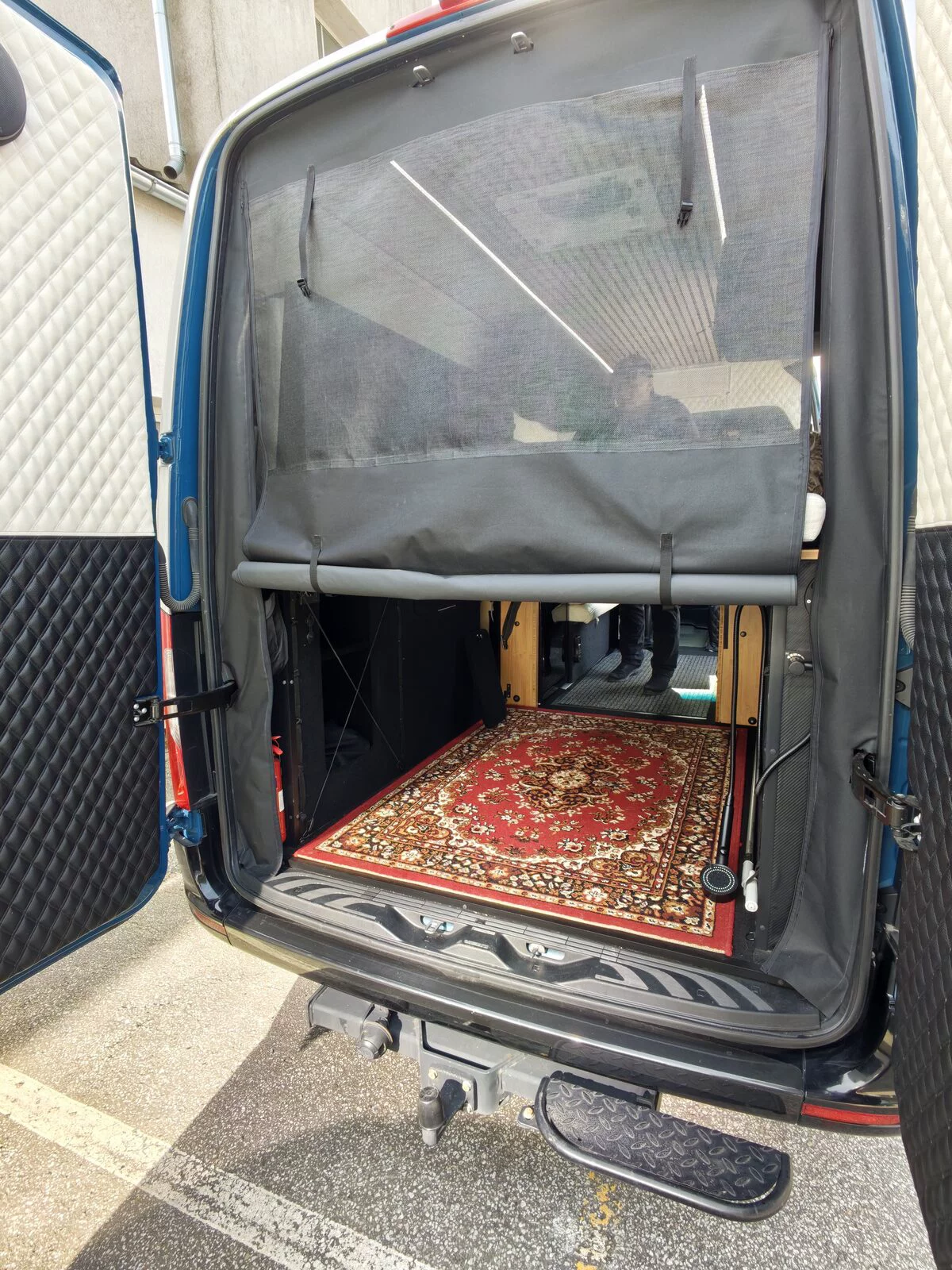Rear of a Sprinter with a mosquito net and a carpet