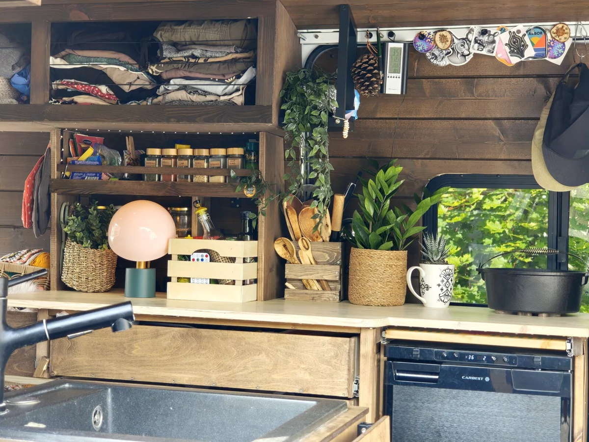 Wooden van kitchen: sink, spices, live plants, fridge