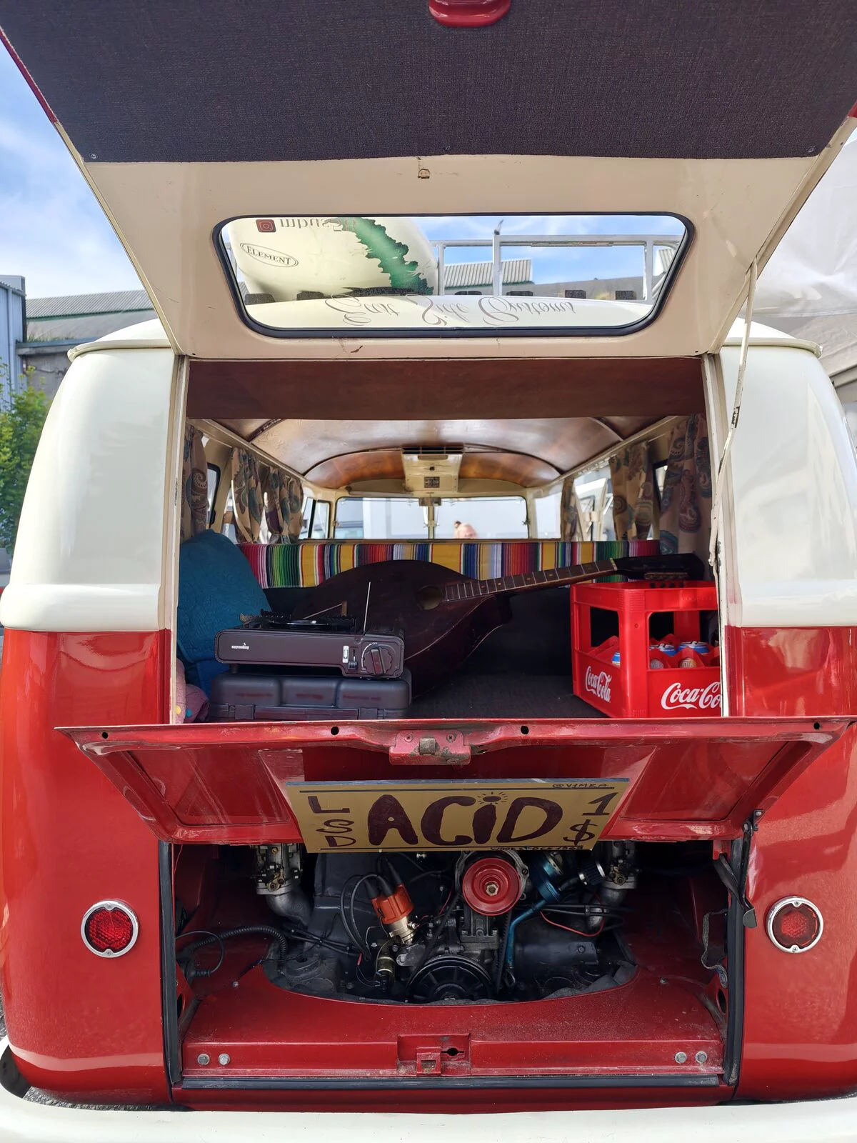Red and white VW T1 with the engine bay open